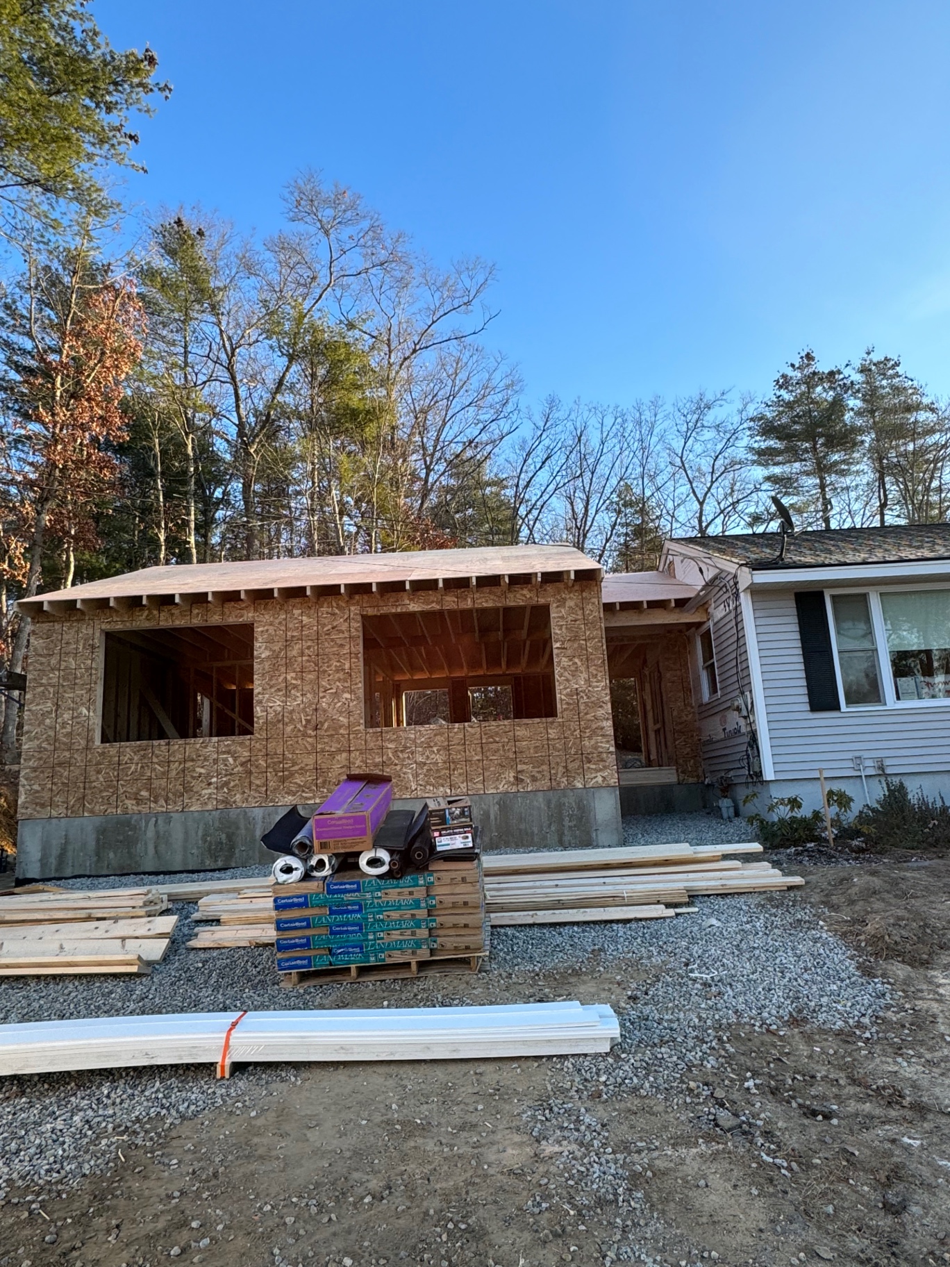 Exterior framing — walls sheathed and roof decked, windows roughed in and ready for weather barrier.