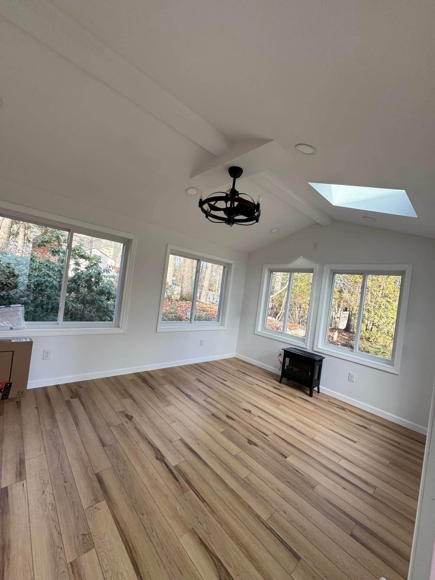 Interior — vaulted ceiling with skylight, recessed lighting, and new wide-plank flooring.