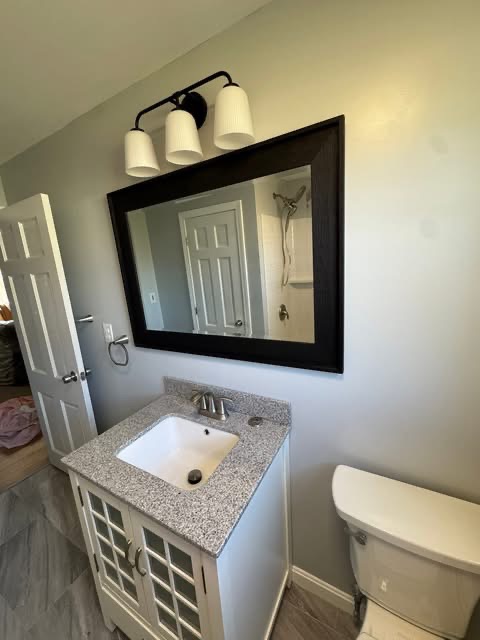 Close-up of the new vanity with undermount sink, brushed-nickel faucet, and framed mirror.