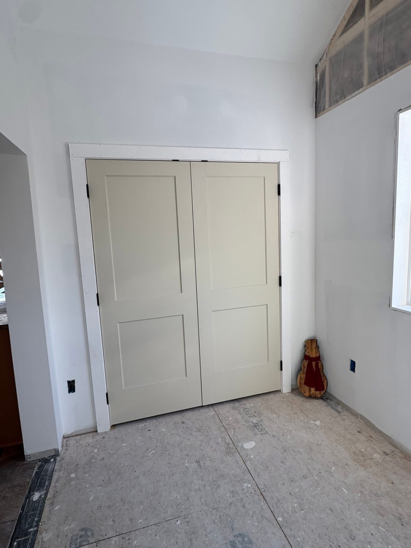 Mudroom addition — completed double-door storage closet with clean white trim in the finished space.