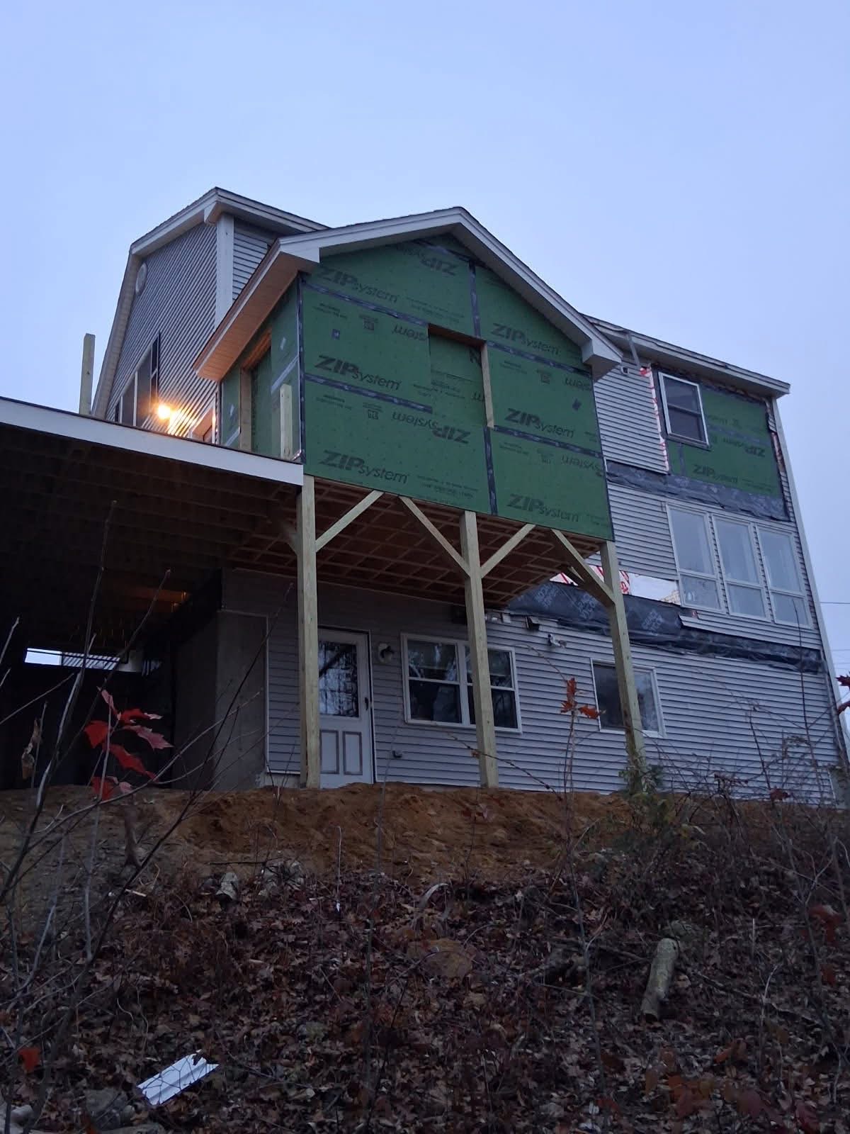Mudroom addition — framed bump-out sheathed in Zip System panels, sitting on new posts above the finished deck.