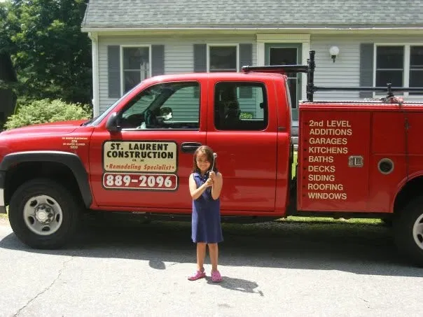 Young girl in front of a branded red St. Laurent Construction truck