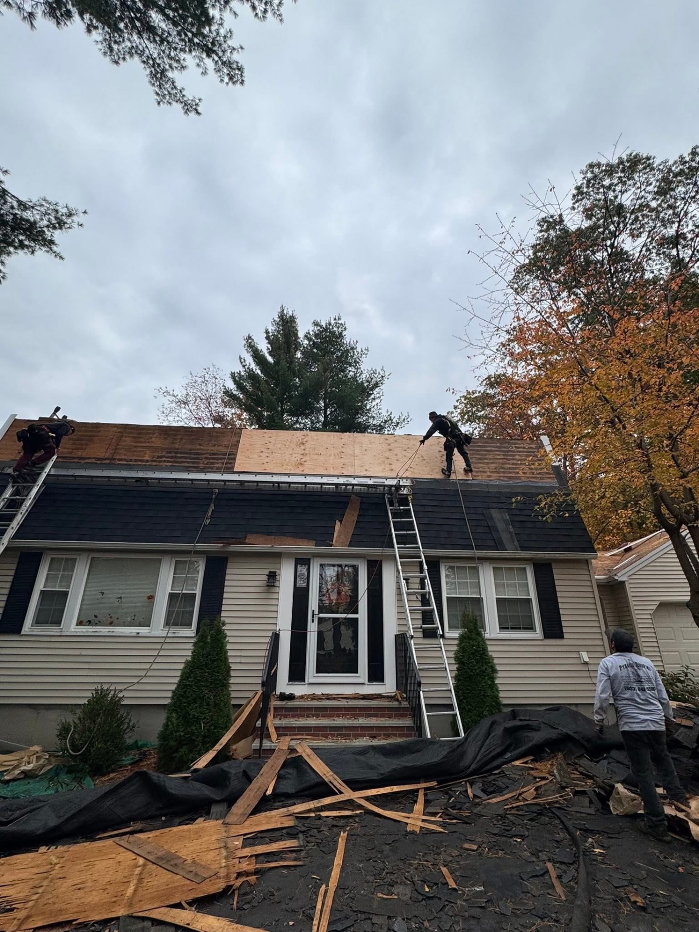 Deck prep — old shingles pulled and new plywood sheathing installed over the front gambrel where the decking needed replacement.