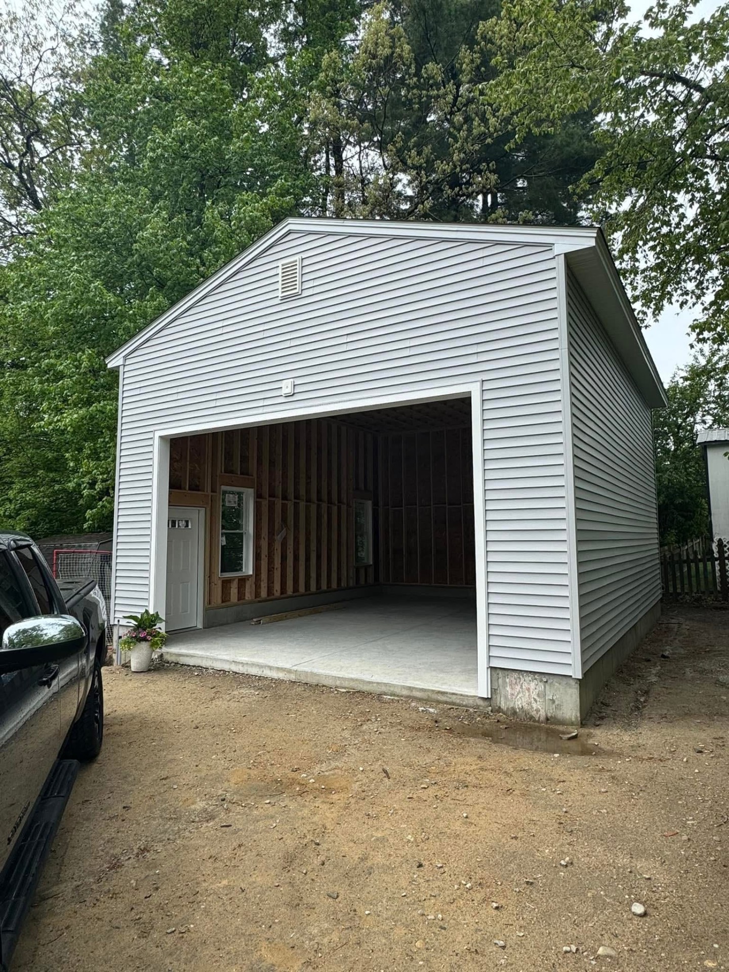 Front view — clean gable end, white door, and finished slab entry.