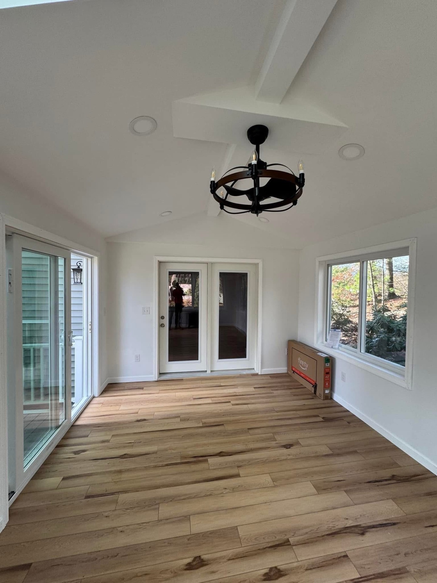 Interior — French doors to the deck, chandelier, and bright natural light throughout the space.