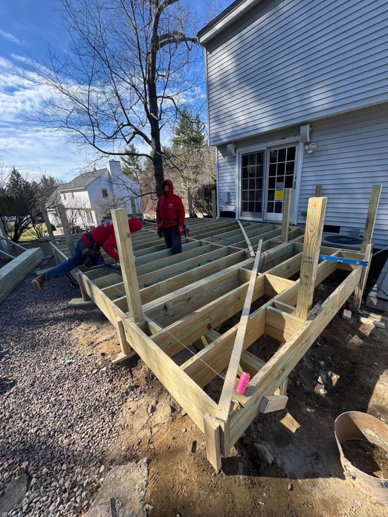 In progress — new pressure-treated posts, beams, and joists going up off the back of the house.